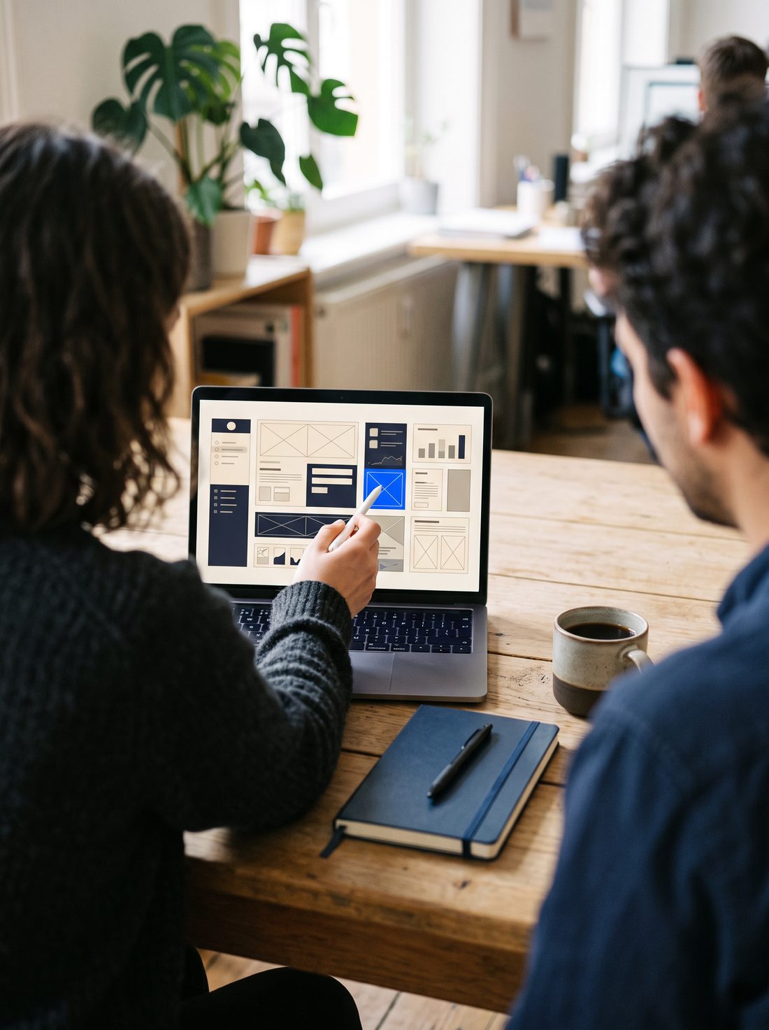 Two designers reviewing an app interface on a laptop